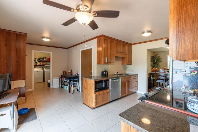 kitchen featuring brown cabinetry, dark countertops, washing machine and dryer, and black appliances