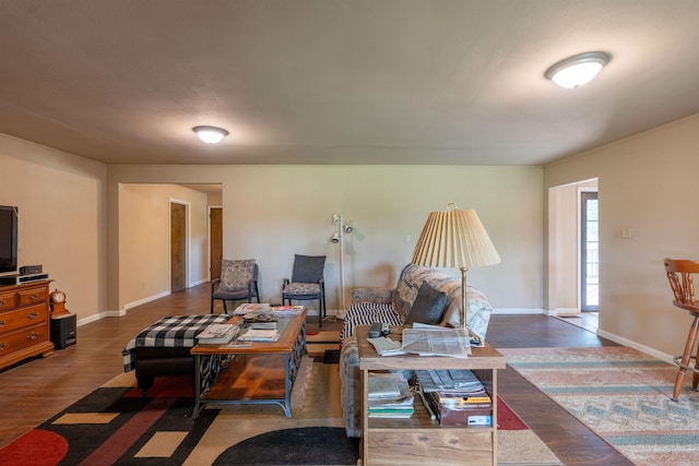 living area featuring dark wood-type flooring and baseboards