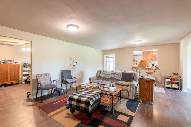 living area with baseboards and wood finished floors