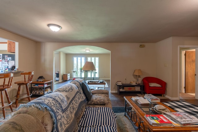 living room featuring arched walkways and baseboards