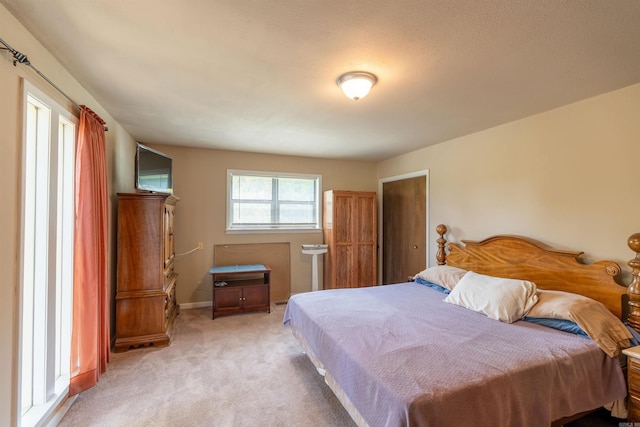 bedroom featuring baseboards and light colored carpet