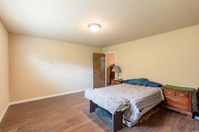 bedroom with dark wood-style floors and baseboards