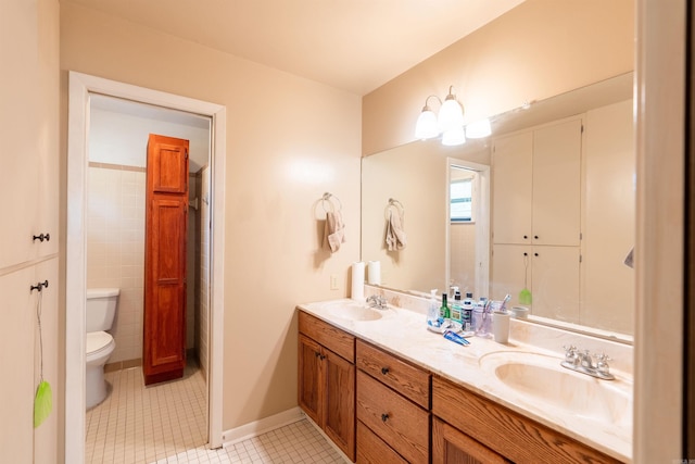 full bathroom featuring double vanity, a sink, toilet, and tile patterned floors