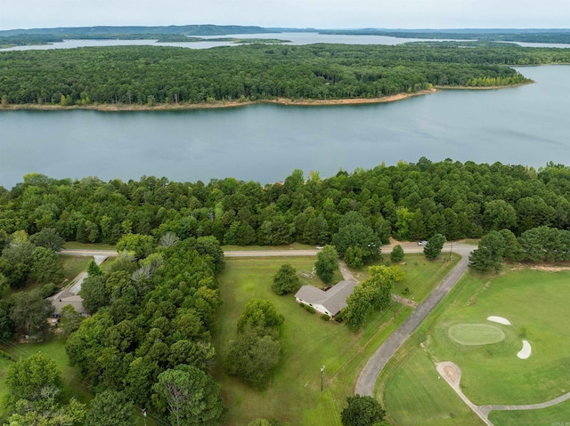 drone / aerial view featuring view of golf course, a water view, and a view of trees