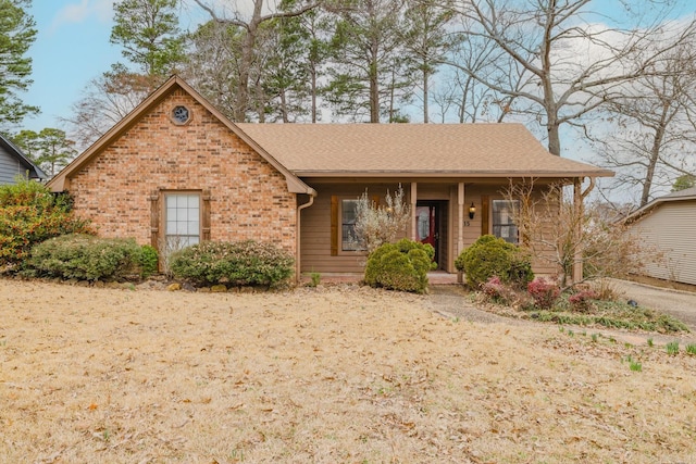 ranch-style house with a shingled roof and brick siding