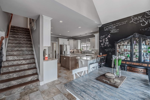 dining room with stone finish floor, recessed lighting, stairway, and ornamental molding