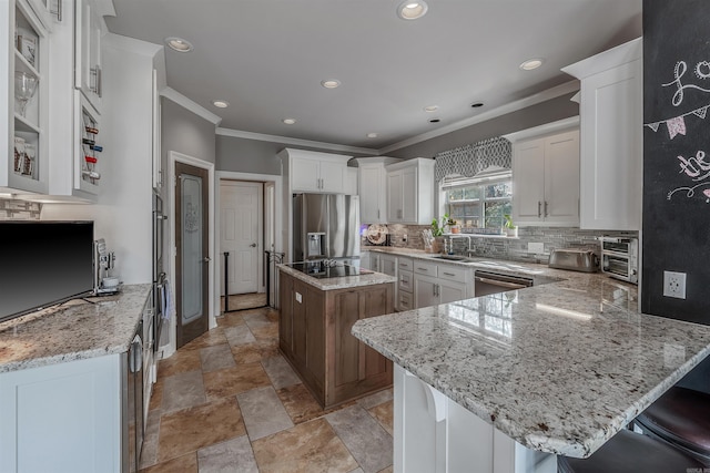 kitchen featuring stainless steel appliances, light stone counters, and a kitchen island