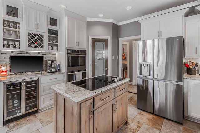 kitchen with light stone counters, beverage cooler, stainless steel appliances, white cabinetry, and tasteful backsplash