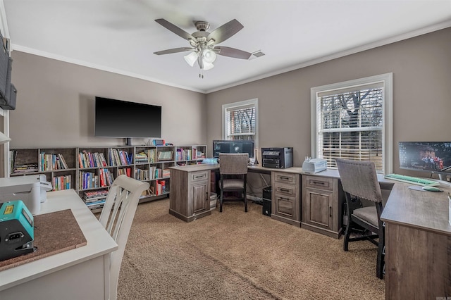 office space featuring light carpet, visible vents, a ceiling fan, and crown molding