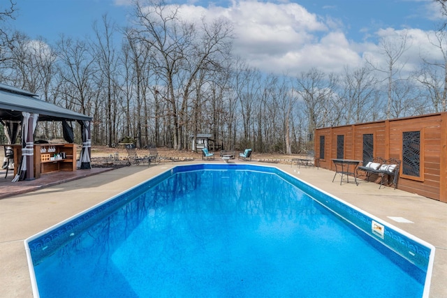 pool with a patio area and a gazebo