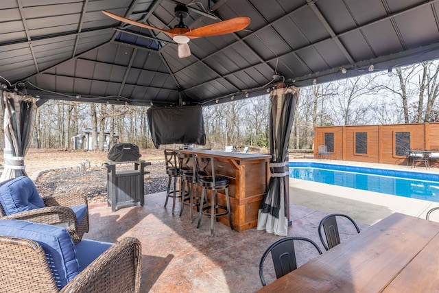 view of patio / terrace featuring ceiling fan, a grill, and outdoor dry bar