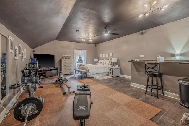 bedroom featuring track lighting, lofted ceiling, dark wood-style flooring, and baseboards