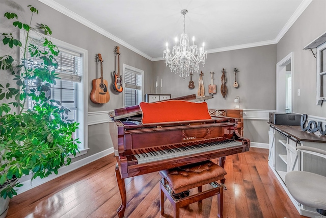 living area with baseboards, wainscoting, ornamental molding, wood finished floors, and a chandelier