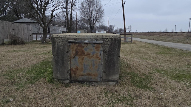 entry to storm shelter with fence and a lawn