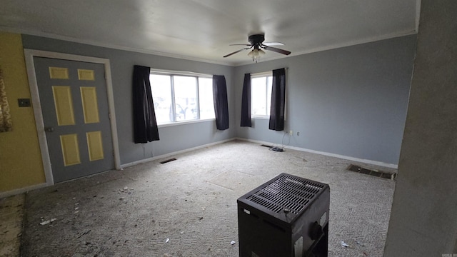 empty room with ceiling fan, ornamental molding, visible vents, and baseboards