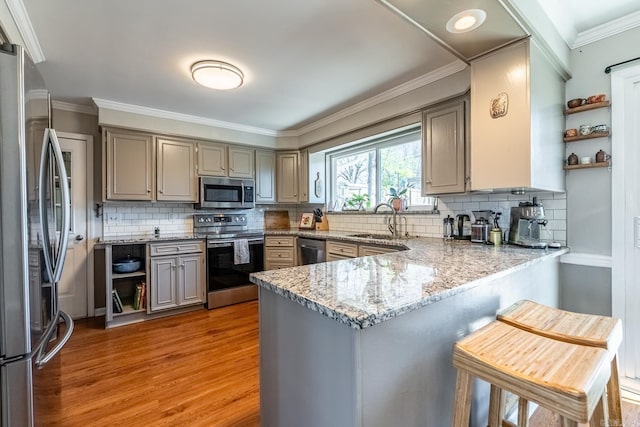 kitchen featuring a sink, stainless steel appliances, a peninsula, and open shelves