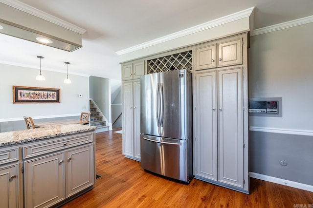 kitchen featuring wood finished floors, crown molding, and freestanding refrigerator