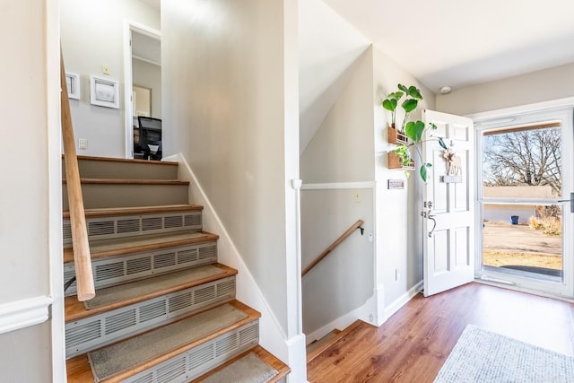 stairway featuring baseboards and wood finished floors