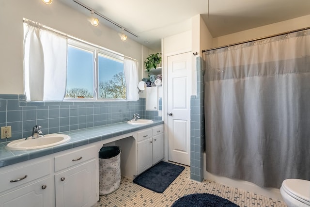 full bath with double vanity, a sink, and tile patterned floors