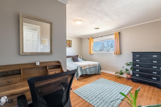 bedroom featuring ornamental molding, visible vents, baseboards, and wood finished floors