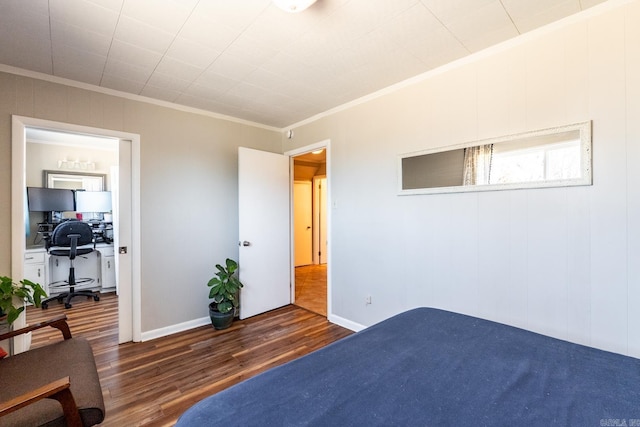 bedroom featuring dark wood-style floors, baseboards, and crown molding