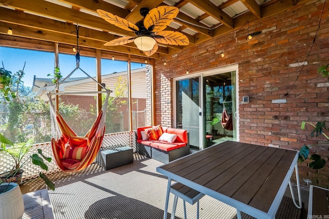 sunroom featuring a ceiling fan and beam ceiling