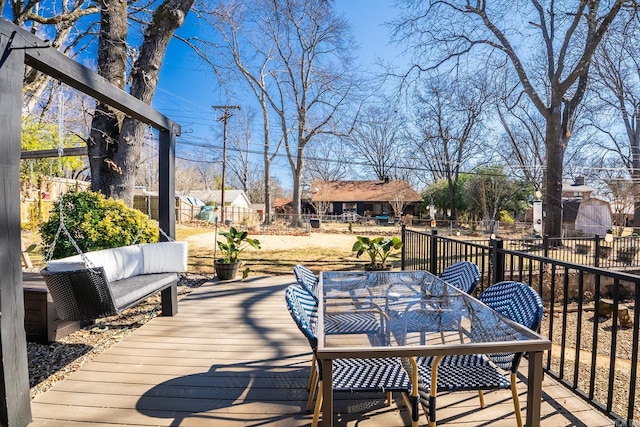 deck with a residential view, outdoor dining area, and a fenced backyard