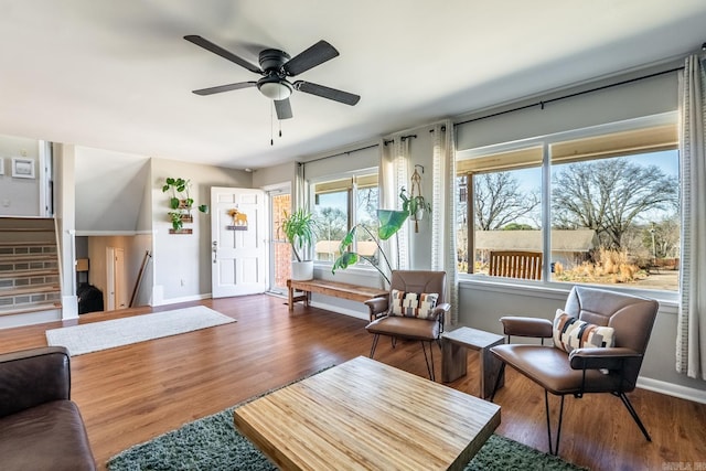 living area with ceiling fan, baseboards, stairway, and dark wood finished floors