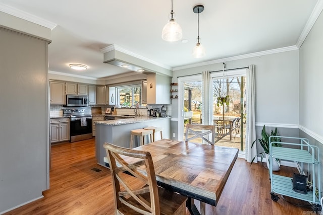 dining area featuring crown molding and light wood-style floors