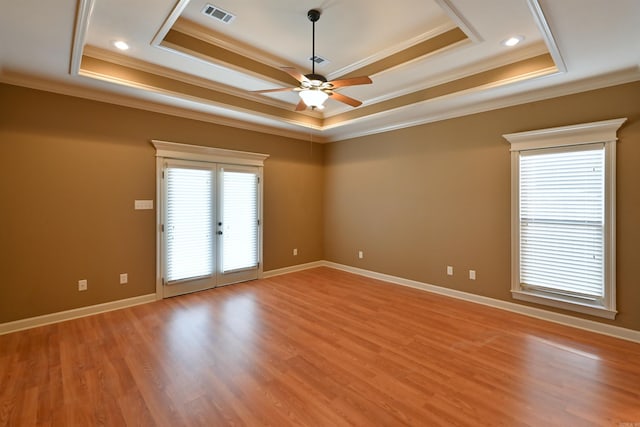 unfurnished room featuring a tray ceiling, french doors, visible vents, light wood-style flooring, and baseboards