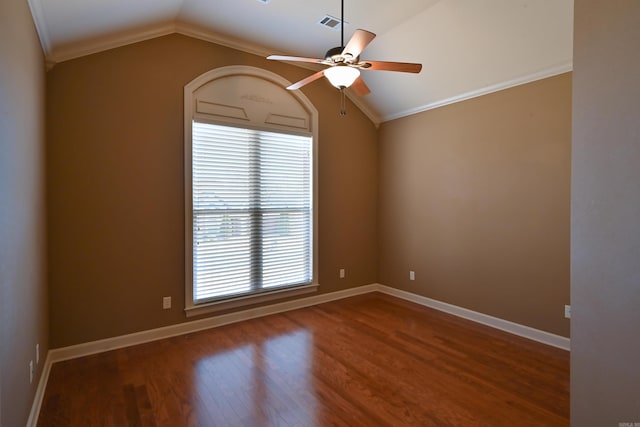 empty room featuring baseboards, a ceiling fan, wood finished floors, vaulted ceiling, and crown molding