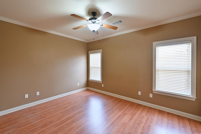 unfurnished room featuring light wood finished floors, visible vents, ornamental molding, ceiling fan, and baseboards