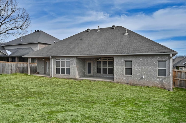 rear view of property with a patio area, a fenced backyard, roof with shingles, and a yard