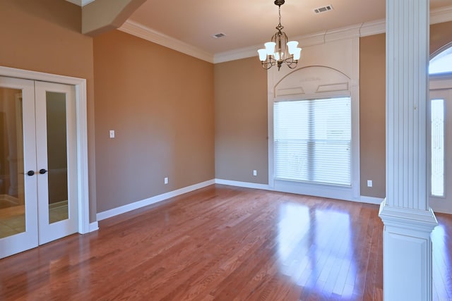 unfurnished room with ornamental molding, french doors, visible vents, and wood finished floors