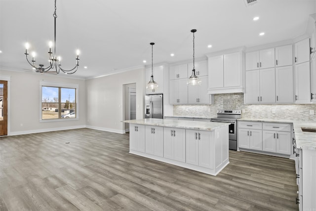 kitchen featuring appliances with stainless steel finishes, open floor plan, white cabinetry, and hanging light fixtures