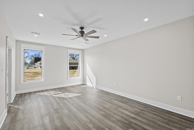 empty room featuring baseboards, wood finished floors, and recessed lighting