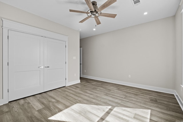 unfurnished bedroom with light wood-style flooring, a closet, visible vents, and baseboards