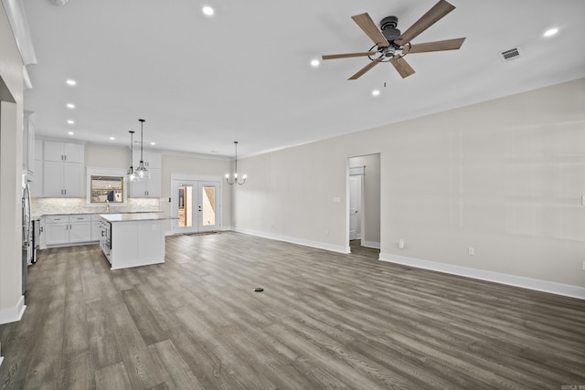 unfurnished living room with visible vents, baseboards, and wood finished floors