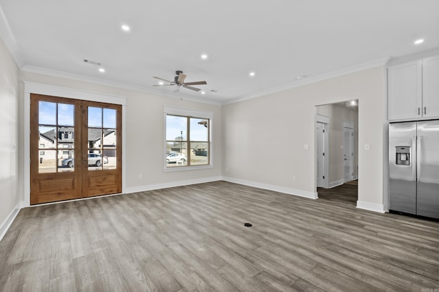 unfurnished living room with baseboards, ornamental molding, french doors, light wood-style floors, and recessed lighting