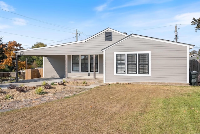 rear view of property featuring a yard, a porch, and fence