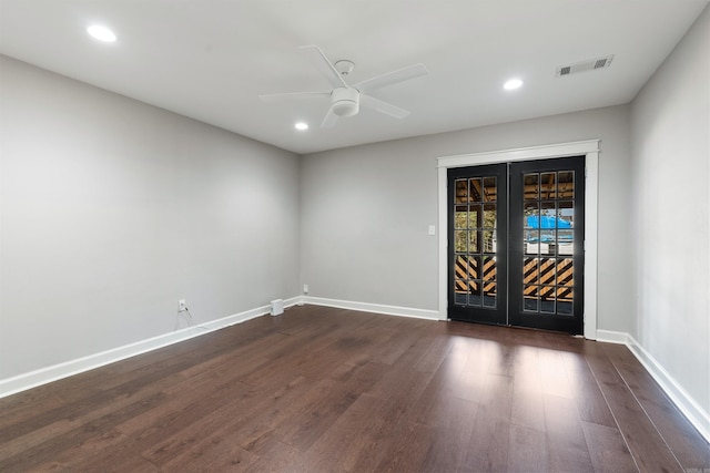 empty room with ceiling fan, dark wood finished floors, visible vents, and baseboards