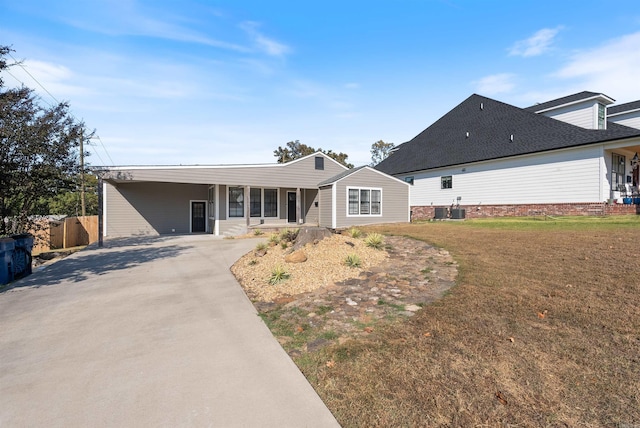 single story home featuring driveway, a carport, and a front yard