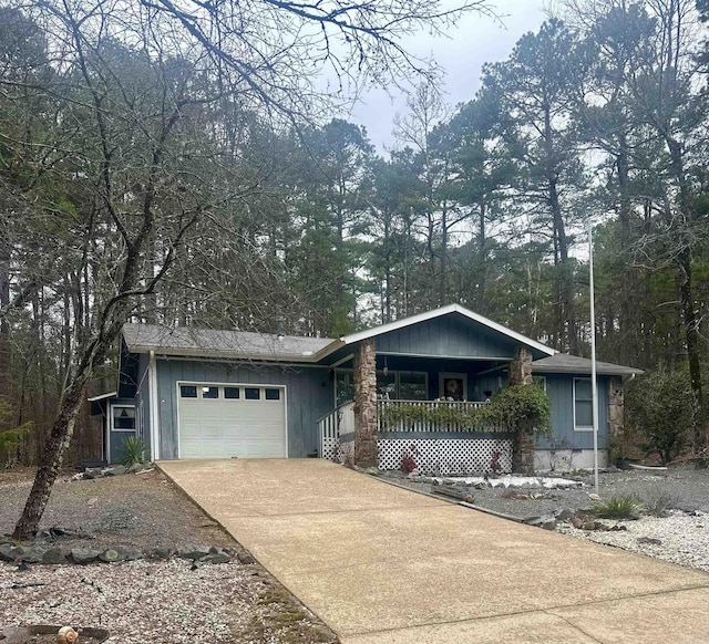 ranch-style home with an attached garage, covered porch, and concrete driveway