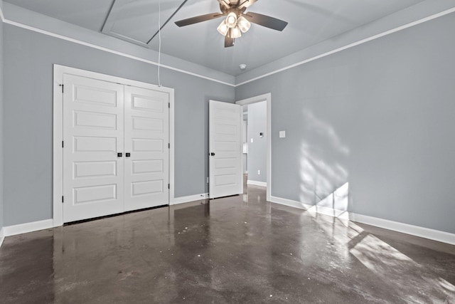 unfurnished bedroom with attic access, a closet, concrete floors, and baseboards