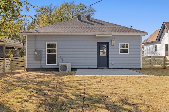 rear view of house featuring a patio, a lawn, a fenced backyard, and ac unit