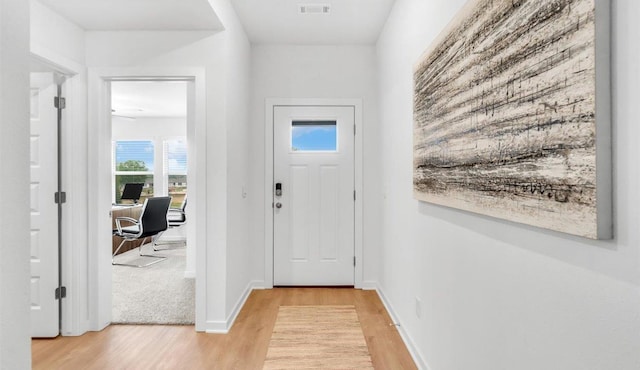 foyer with wood finished floors, visible vents, and baseboards