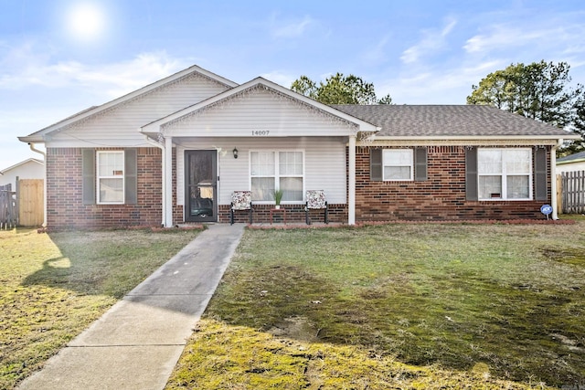 view of front facade featuring brick siding, a front lawn, and fence