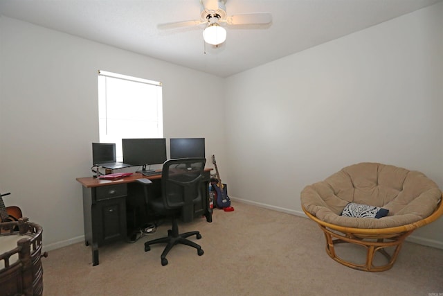 office featuring light colored carpet, ceiling fan, and baseboards