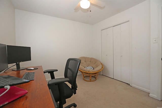 office space featuring light colored carpet, ceiling fan, and baseboards