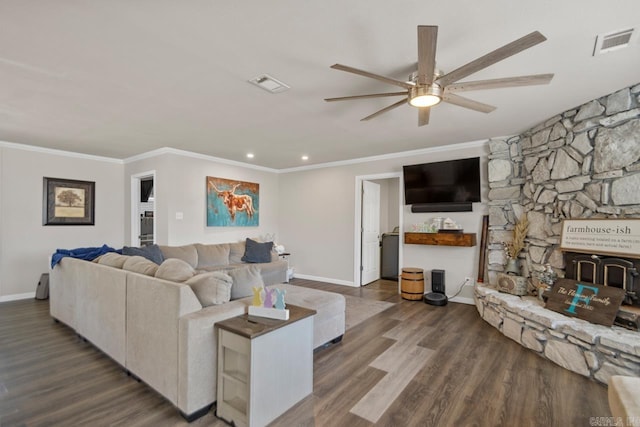 living area with ornamental molding, visible vents, dark wood finished floors, and baseboards